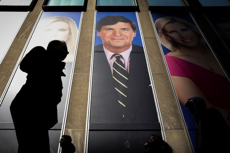 People pass by a promo of Fox News host Tucker Carlson in New York, the US, March 13 2019. Picture: BRENDANMCDERMID/REUTERS